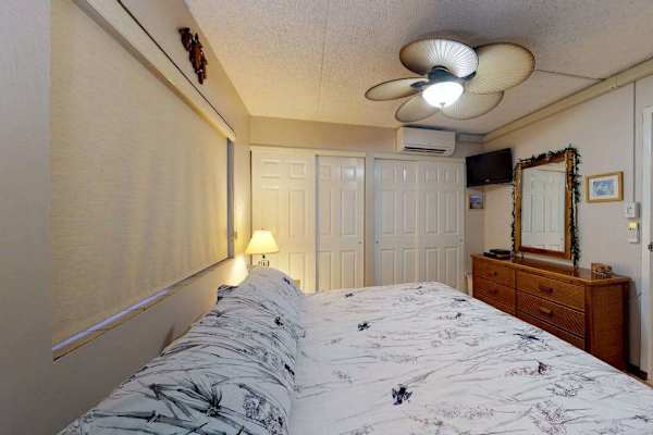 Bright bedroom with ceiling fan and ample storage