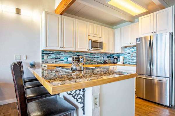 Modern kitchen with breakfast bar and four barstools for extra seating.