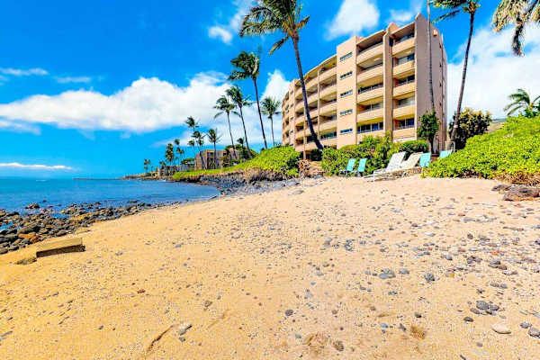 Crystal-clear turquoise waters gently wash onto pristine white sandy beaches.
