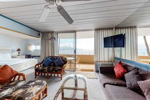 Bright living room with sliding glass doors, abundant natural light, flat screen tv and a comfortable sofa bed for extra guests.
