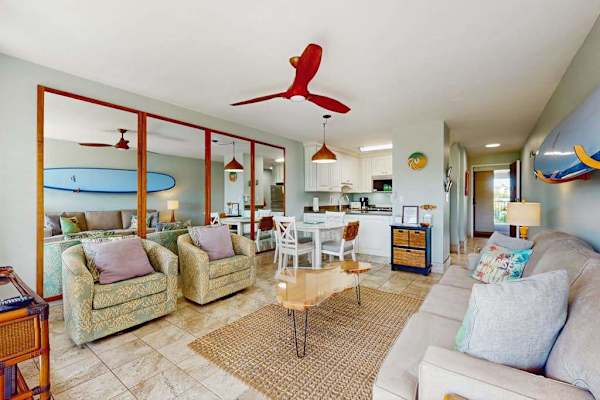 Cozy living room with surf-inspired décor, a flat-screen TV, a comfortable sofa bed, and direct access to the private lanai.