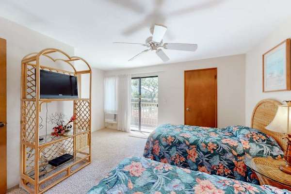 First floor bedroom with rattan accents and lanai access