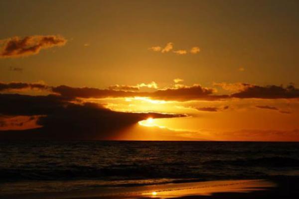 Take in a breathtaking ocean sunset as golden skies glow over the water, creating an unforgettable island view