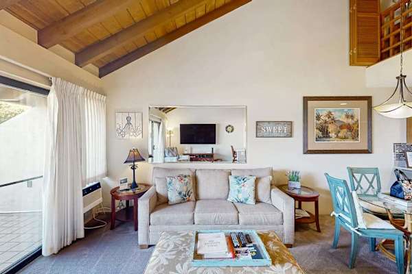 Cozy Living Space with Sofa, Wall Mirror, and Adjacent Dining Set