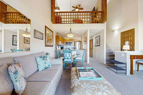 Bright Living Area with Plush Sofa, Loft View, and Entryway
