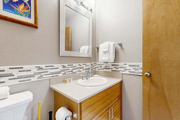 Compact Bathroom Vanity with Mirror and Decorative Wall Tiling
