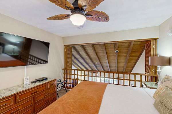 Loft Bedroom with King Bed, Mounted TV, and Vaulted Ceiling View