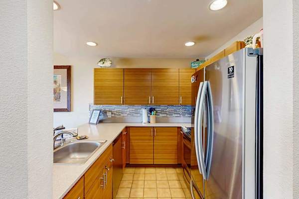 Fully Equipped Kitchen with Modern Cabinetry and Stainless Steel Refrigerator