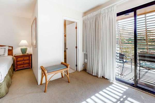 This bedroom offers comfortable furnishings abundant sunlight and balcony access