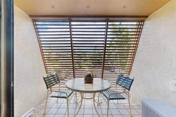 Covered patio dining offers shaded seating beneath palms and greenery