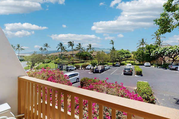Balcony railing overlooks palm gardens parking and bright Maui skies