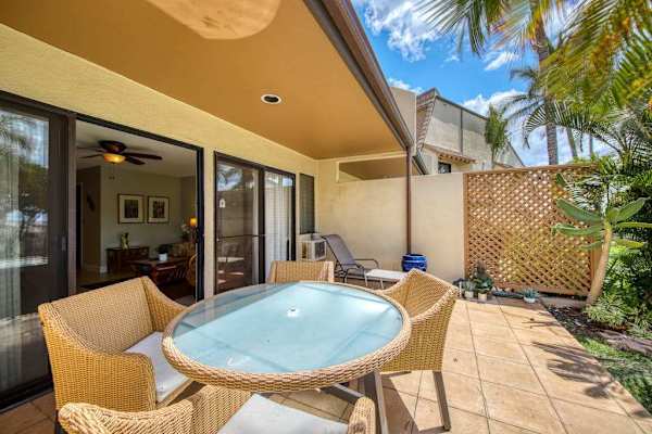 Covered patio dining offers relaxed seating beside tropical greenery outdoors