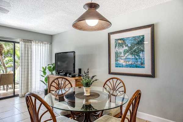 Rattan dining table welcomes meals beside kitchen and garden views