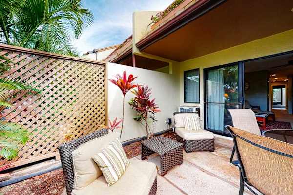 Covered patio seating extends comfortable living into lush tropical outdoors