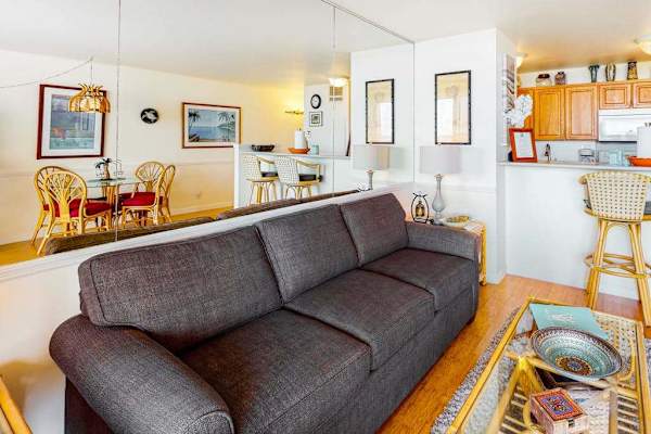 Living room with sleeper sofa and a flat screen tv.  Lots of natural light streaming in from the lanai.