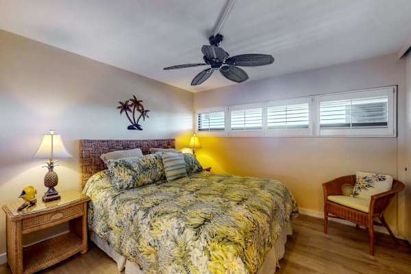 Primary bedroom with king bed, ceiling fan, and en suite bathroom 