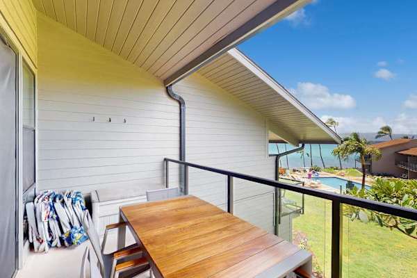 Covered balcony provides outdoor dining with ocean and garden views