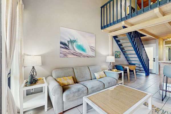 Open living space offers sofas, dining access, and ocean views