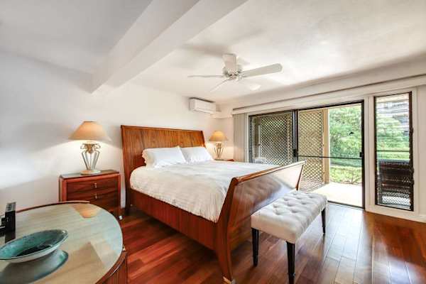 Primary Bedroom with Plush Bed, Bedside Tables, and Direct Outdoor Patio Access