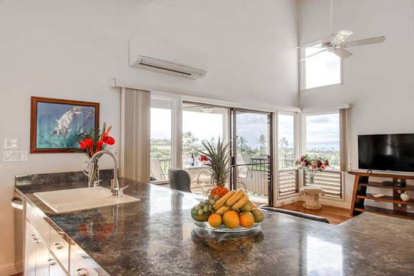 Granite Kitchen Counter with Fresh Fruit Bowl and Living Area View