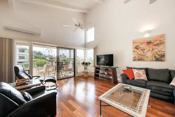Bright Living Room with Vaulted Ceilings, Leather Seating, and Patio Access