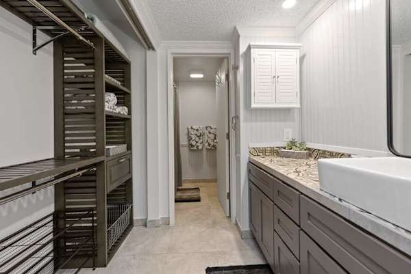 Full bathroom features long vanity bright mirror and walk-in shower