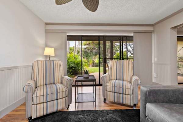 Cozy sitting nook offers two armchairs beside sunny garden windows