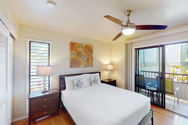 Cozy Bedroom Featuring Queen Bed, Ceiling Fan, and Sliding Glass Balcony Door