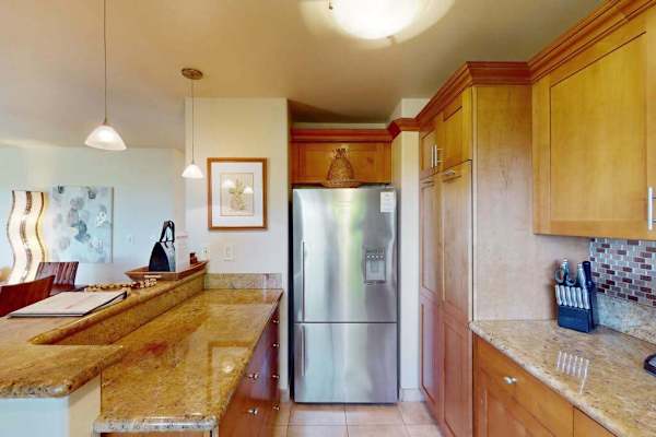 Modern Kitchen View Highlighting Stainless Steel Refrigerator and Granite Countertops
