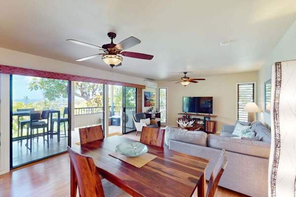 Spacious Dining and Living Area with Wooden Table, TV, and Covered Lanai Access