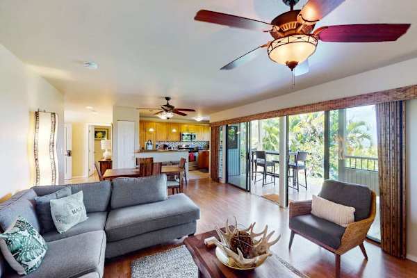Open-Concept Living Room with Sectional Sofa, Ceiling Fan, and Large Sliding Glass Doors