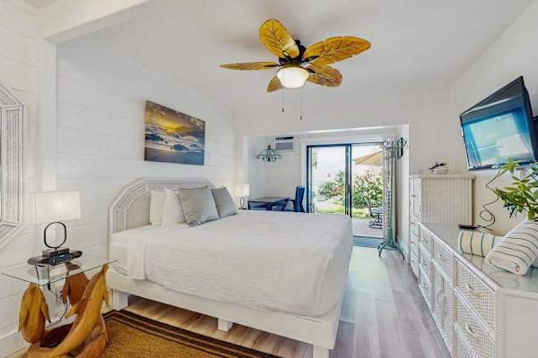 Recharge in the inviting guest bedroom with direct access to the tropical patio.