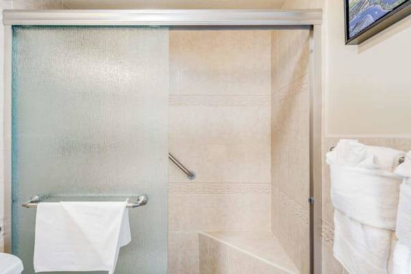 Glass shower enclosure with fresh plush towels provided