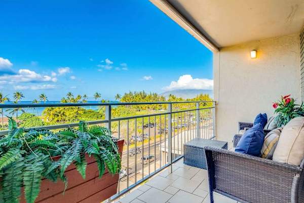 Covered private balcony with comfortable seating and tropical plants