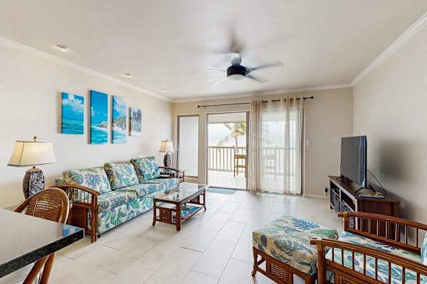 Living room offers ceiling fan seating and expansive balcony views
