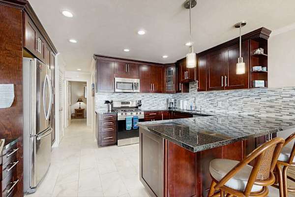 Kitchen dining space shares warm cabinetry and bright natural light
