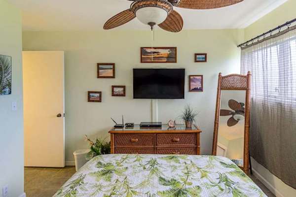 Comfortable queen bedroom with television and fresh linens for restful relaxing stays