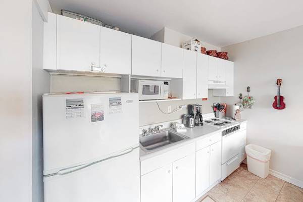 Spacious kitchen showcases refrigerator microwave oven and generous counter space