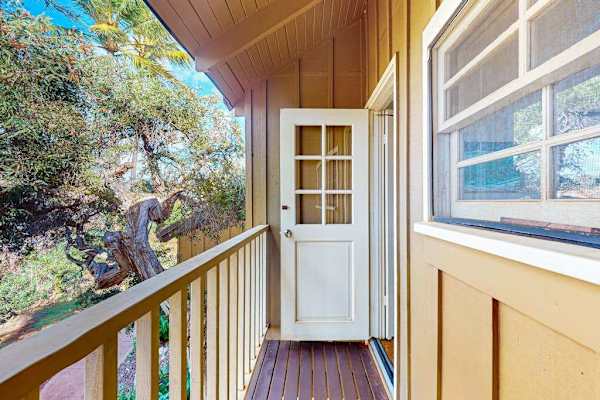 Covered balcony provides a welcoming entry with tropical outdoor views