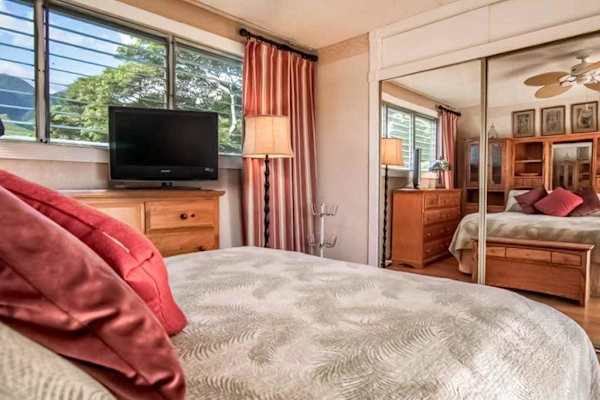 Bright bedroom features scenic window views and a large mirror for added convenience