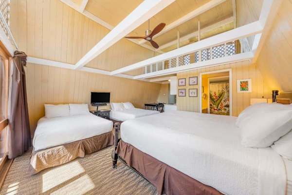 Sleeping area features comfortable bedding and warm wood accents