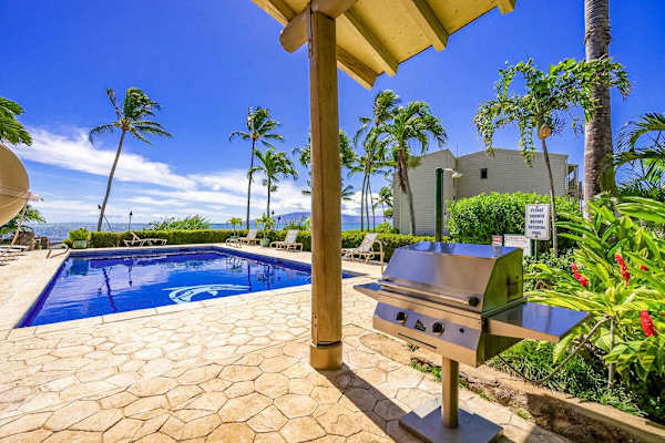 Barbecue area offers grill, ocean views, palms, and shaded shelter