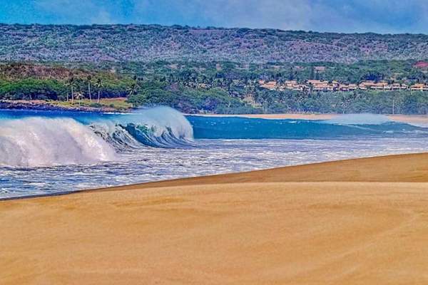 Nearby beach offers golden sand, calm waves, hills, and shoreline