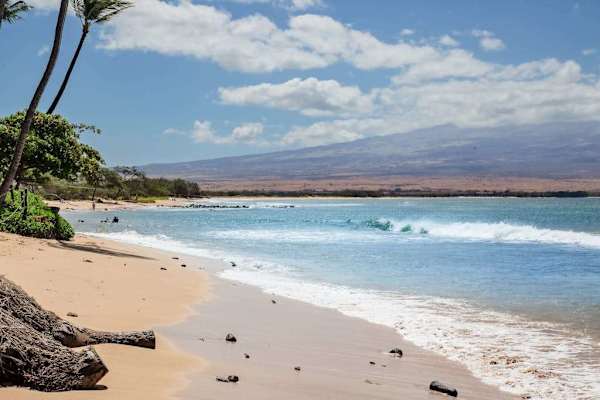 Crystal-clear turquoise waters gently wash onto pristine white sandy beaches.