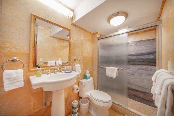 Full bathroom with a walk-in shower, fresh towels, and complimentary essentials for a comfortable stay.