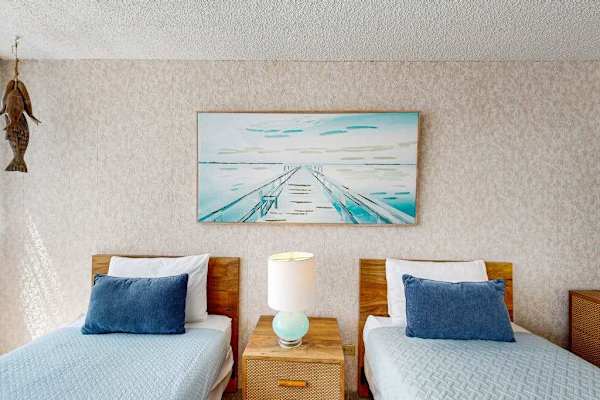 Two comfortable twin beds with plush linens provide a restful night's sleep after exploring Honolulu.