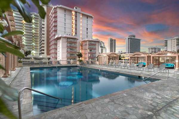 Guests have access to the building's expansive shared pool deck, which features a large swimming pool, ample lounge chairs, and shaded cabanas.