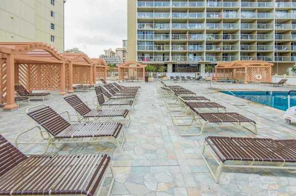 Soak up the warm Hawaiian sun on the spacious outdoor pool deck, offering rows of comfortable lounge chairs and plenty of space to relax by the water.