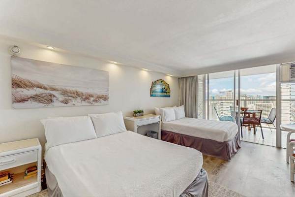 The open-concept studio features two full sized beds and direct access to the balcony.