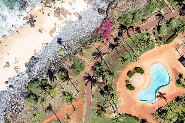 Aerial view maps resort pool, beach, paths, lawns, and landscaping